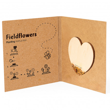 Corazón de semillas de flores silvestres en madera natural