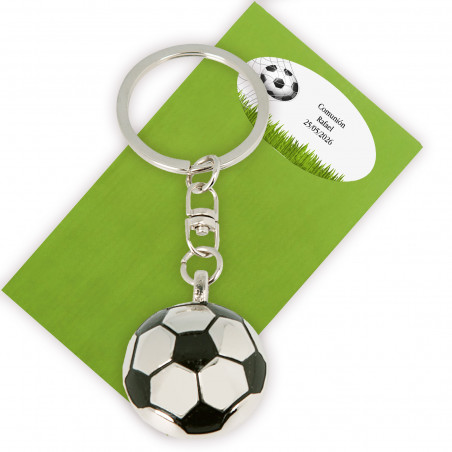 Llavero en forma de balón de fútbol presentado en sobre verde y adhesivo con texto